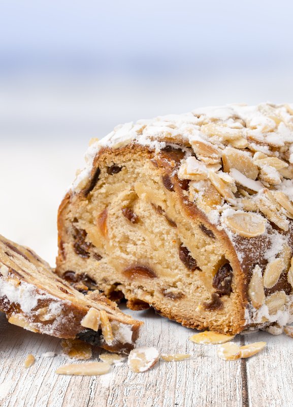Der Stollen, gefüllt mit Trockenfrüchten und Nüssen, ist mit Puderzucker bestreut und sieht verlockend aus.