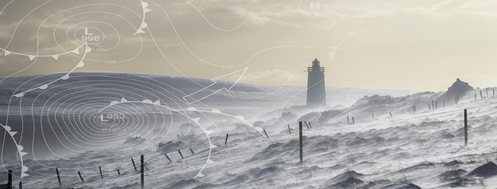 In einer winterlichen Szenerie zeigt sich ein Leuchtturm, umgeben von schneebedeckten Hügeln und starkem Wind.
